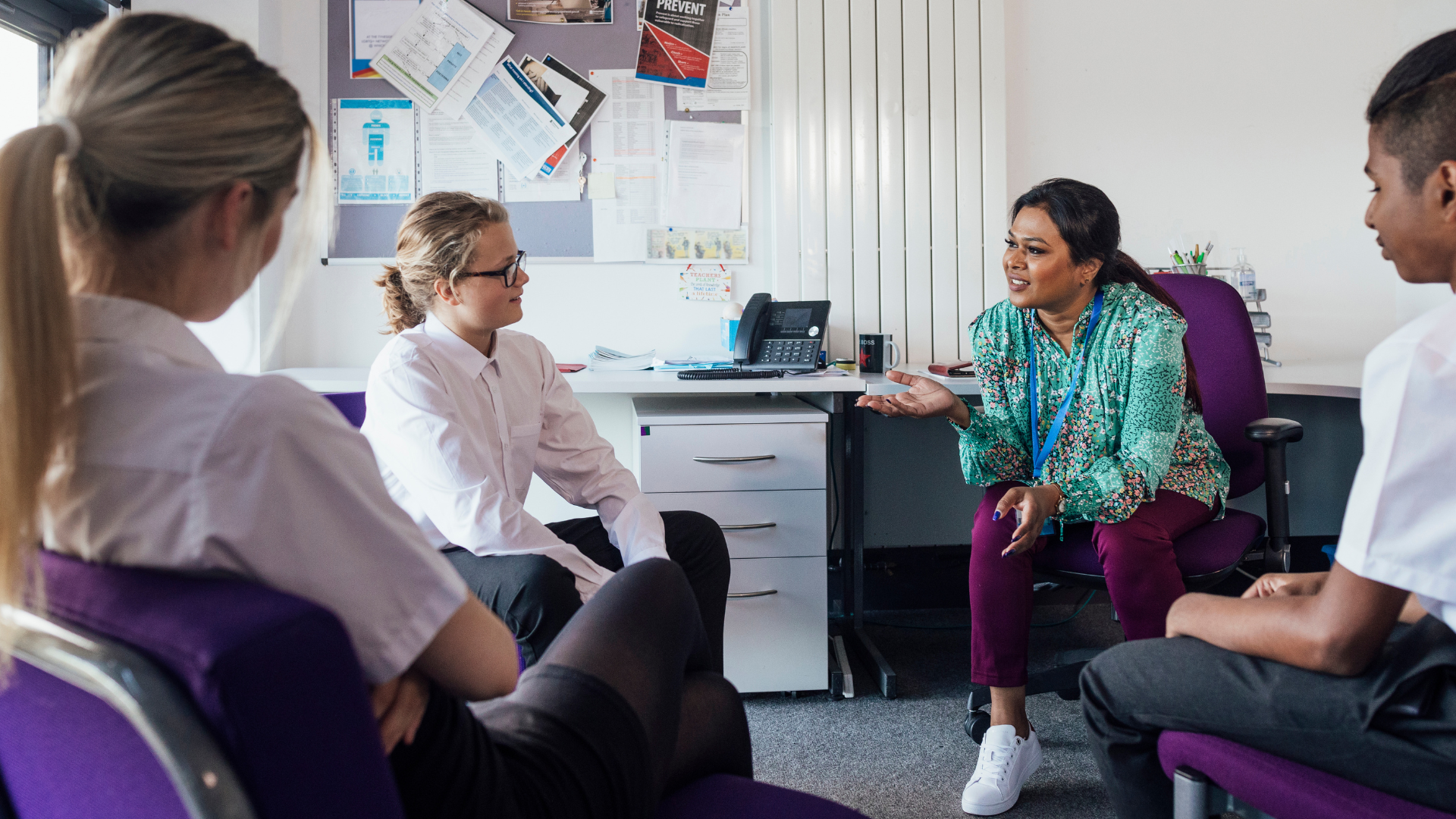 Therapist talking to a few young teens in her office