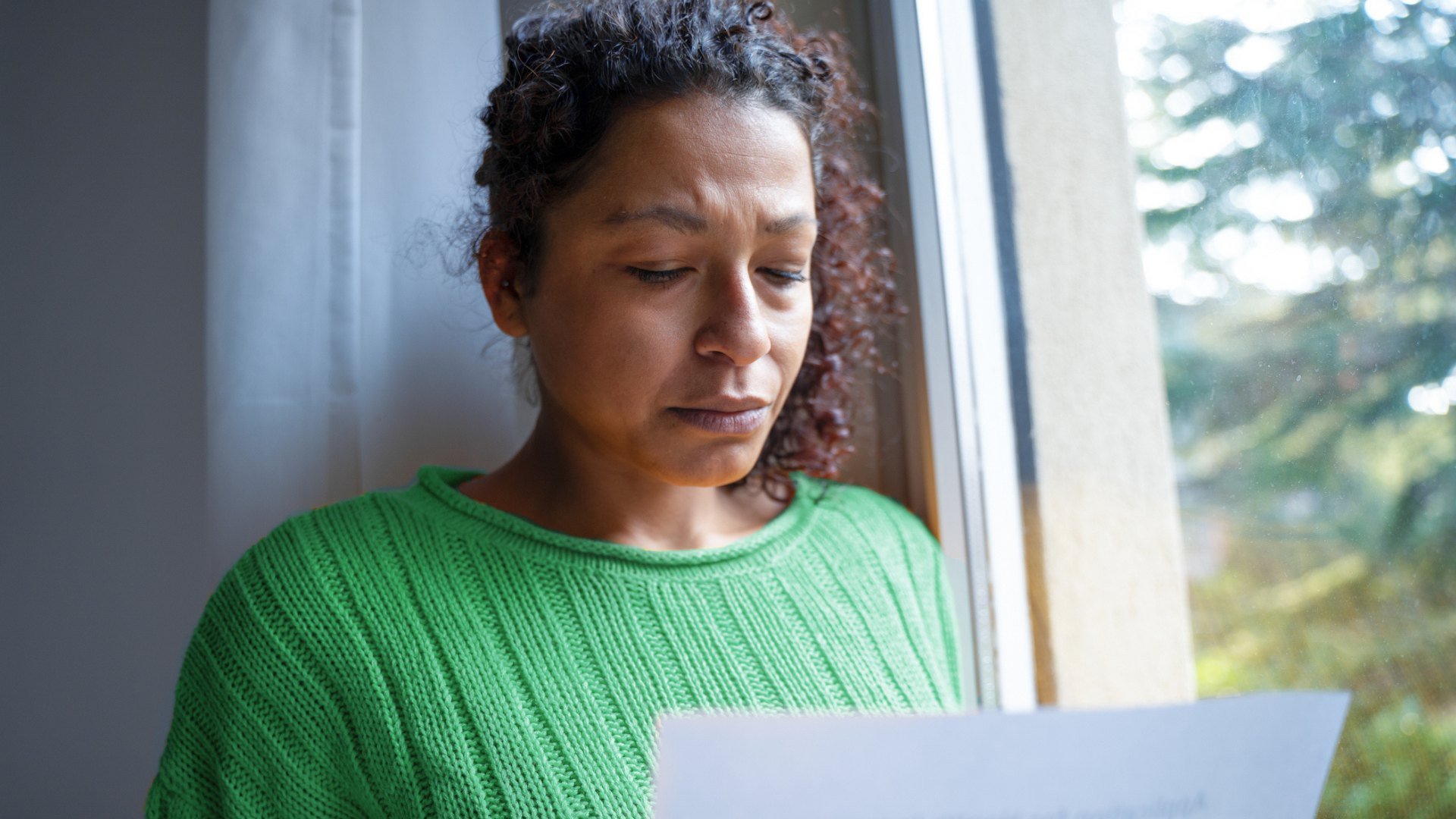 Woman looking distraught at a piece of paper