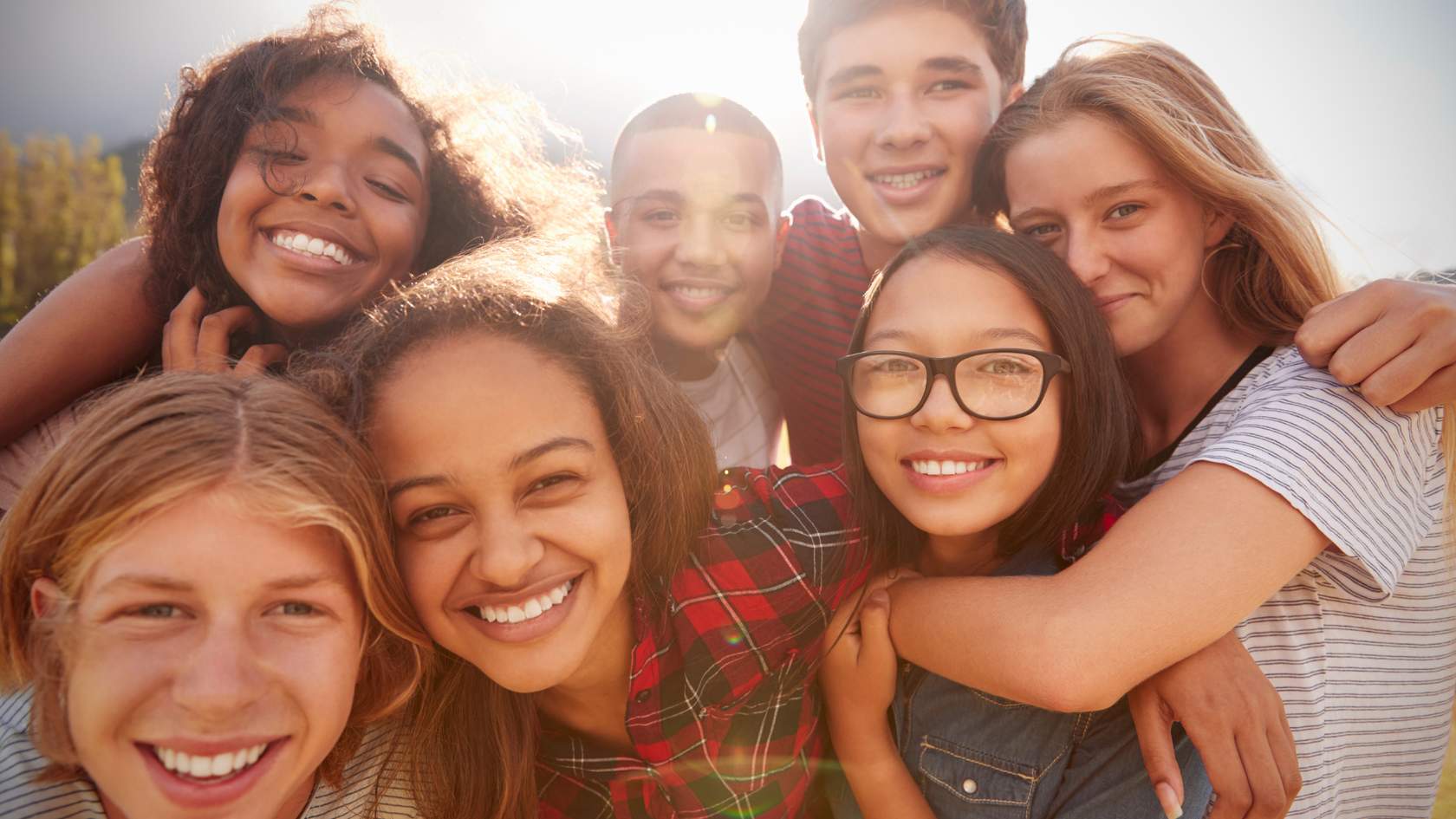 Group of teenagers smiling and hugging eachother