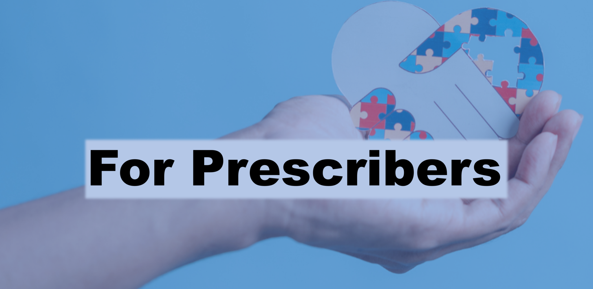 Text: For Prescribers and image of close up of hand with cutout of 2 hands in a handshake in the shape of a heart and one is made of colorful puzzle pieces