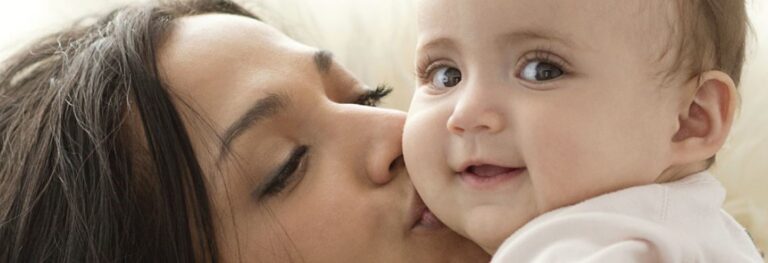 mom kissing baby's cheek