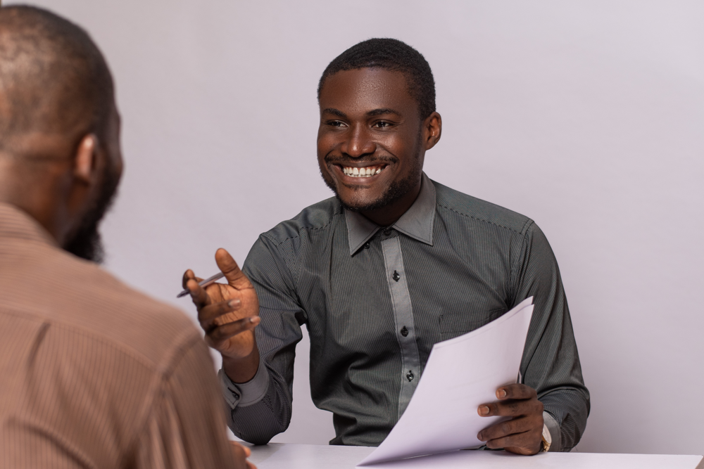 Two men in a meeting in converstaion at a desk